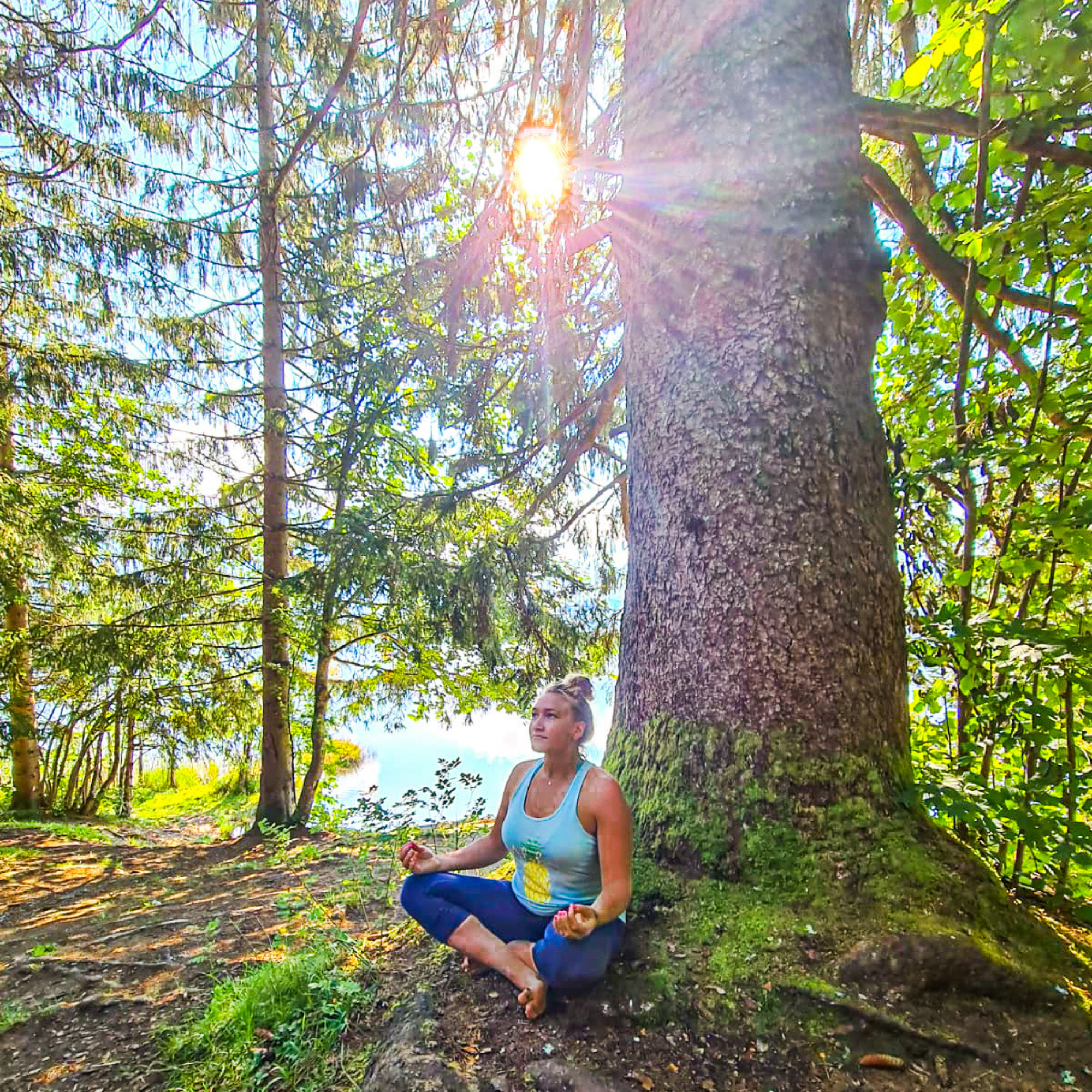 Eileen Kraus meditierend in der Natur vor einem Baum